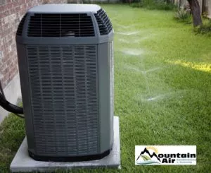 Heat pump in yard with Mountain Air logo in bottom right corner